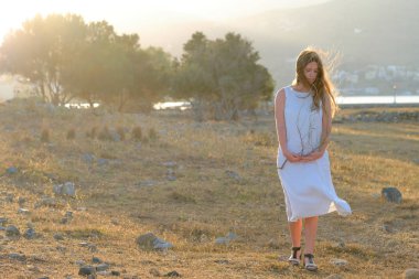 Zeytin ağacı yakınındaki elbiseli genç kız