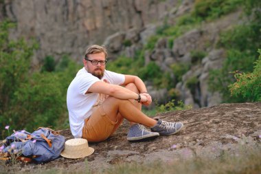 Kanyon cliff üzerinde oturan bir sakallı genç adam