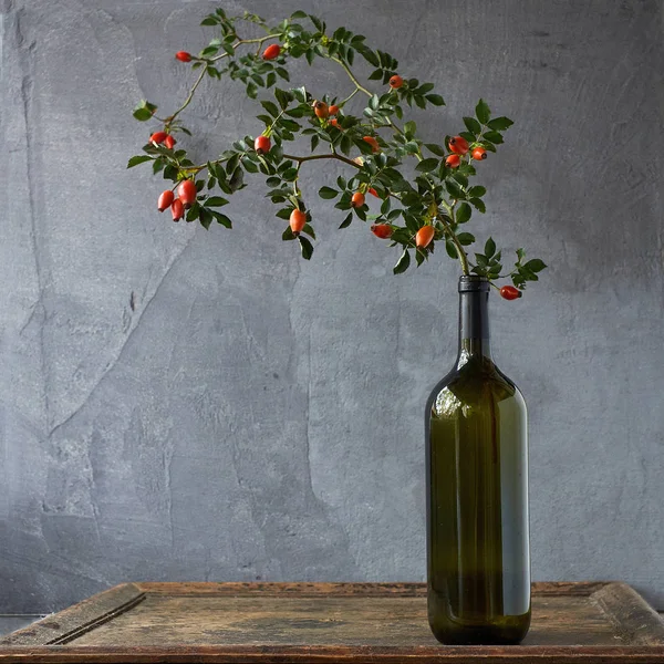 Botella de aceite esencial de rosa mosqueta sobre fondo de madera — Foto de Stock