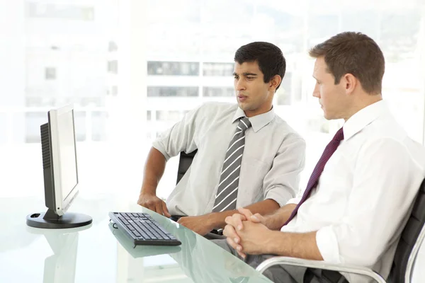 Manager schult einen jungen Geschäftsmann am Arbeitsplatz — Stockfoto