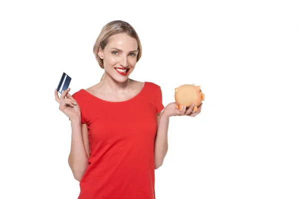Счастливая женщина с кредиткой и копилкой — стоковое фото