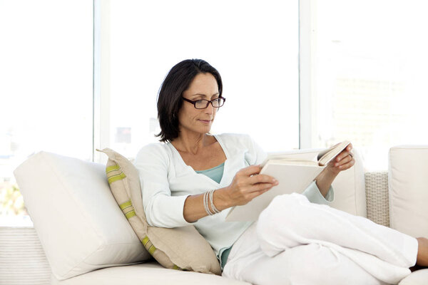 Woman reading a book at home