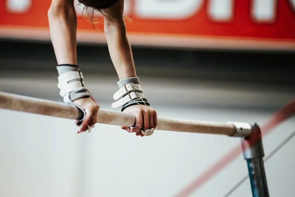 girl gymnast exercise on uneven bars