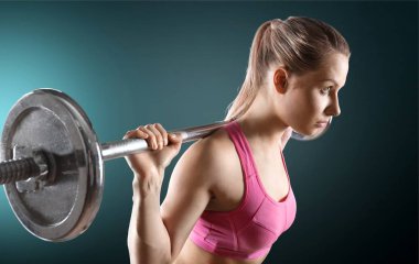 Kadın halterle egzersiz yapıyor.