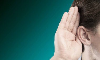 İşadamı kulak yakınındaki elini tutar 