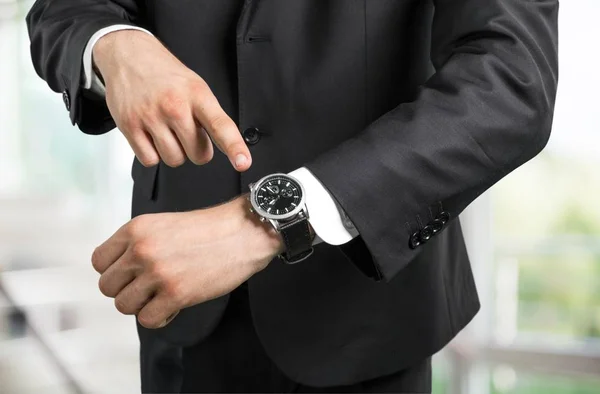 Uomo d'affari che punta a portata di mano orologio — Foto Stock