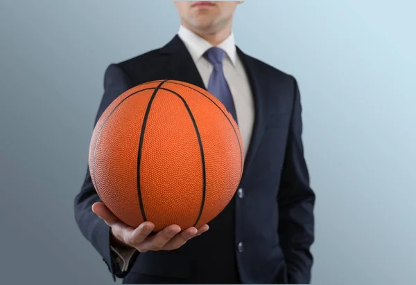 Empresário de terno segurando bola de basquete — Fotografia de Stock