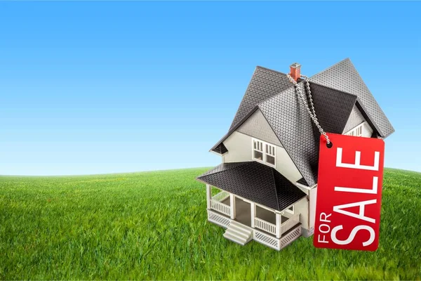 "продается "-знак и модель дома — стоковое фото