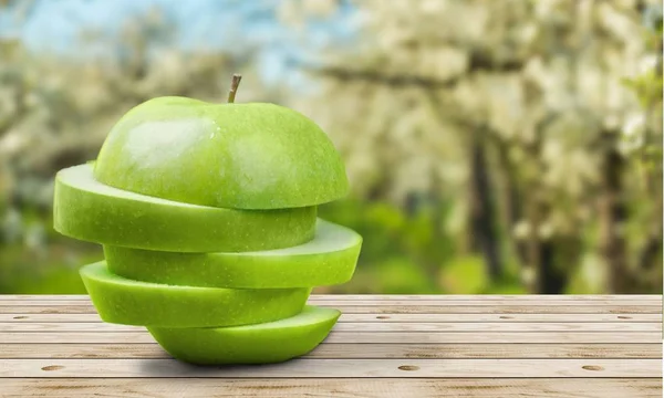 Нарезанное зелёное яблоко на столе — стоковое фото