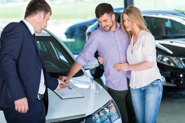 Feliz pareja con concesionario de coches — Foto de Stock