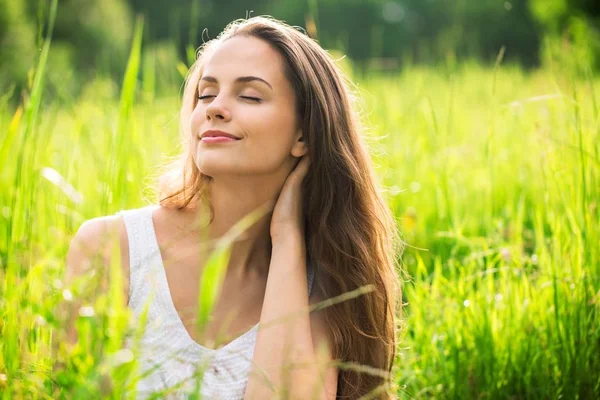 Vrouw op veld onder zonsondergang licht — Stockfoto