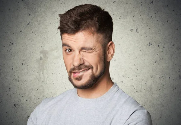 Jonge man knipogen van een oog — Stockfoto