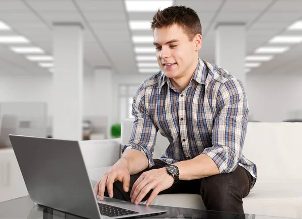 Homem relaxante no sofá com um laptop — Fotografia de Stock