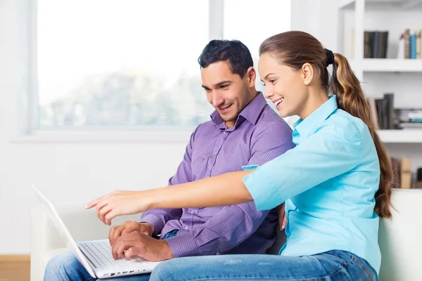 Happy beautiful couple using laptop — Stock Photo, Image