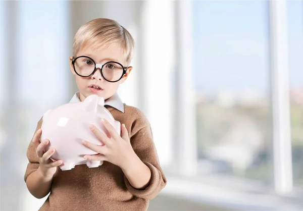 Pensativo chico holding piggybank —  Fotos de Stock