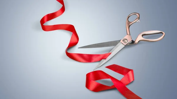 Ножницы и красная лента на белом — стоковое фото