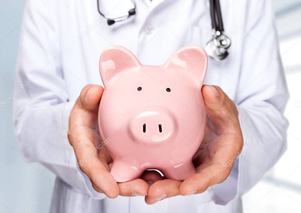  Doctor with Stethoscope Holding Piggy Bank
