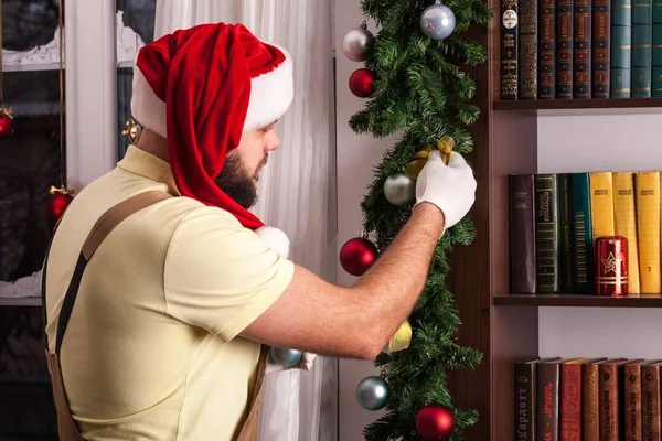 Ο άνθρωπος στη Santa καπέλο σπίτι διακόσμηση — Φωτογραφία Αρχείου