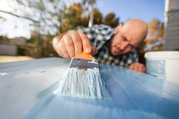 Homem com pintura pincel na placa de madeira — Fotografia de Stock