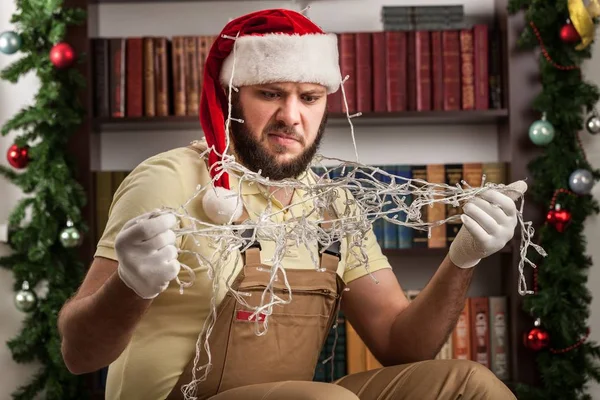 男人试图修复圣诞树灯 — 图库照片