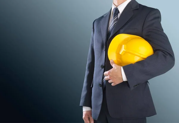 Biznesmen, trzymając w ręku żółty kask — Zdjęcie stockowe