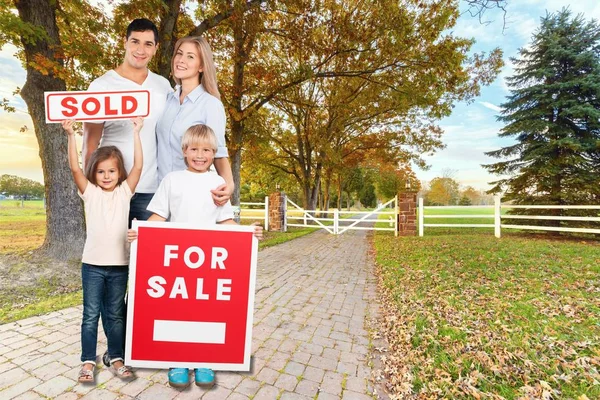 Glückliche Familie mit Verkaufsschild — Stockfoto