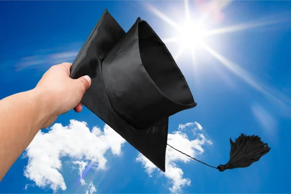 Main jetant chapeau de graduation dans l'air . — Photo