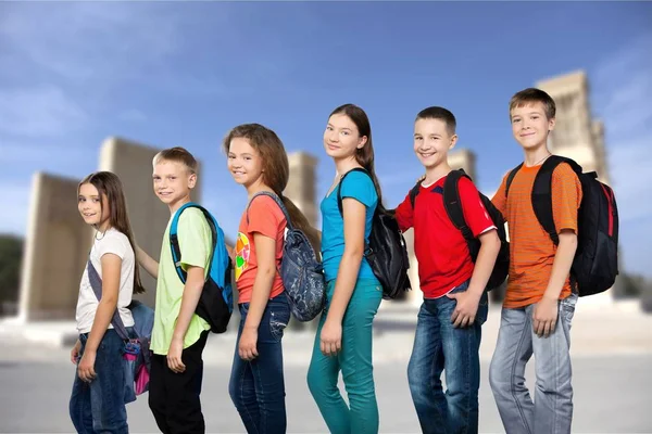 Vänliga skolbarn med ryggsäckar — Stockfoto