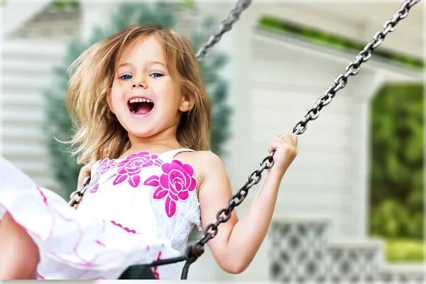 Маленькая девочка веселится на качелях — стоковое фото