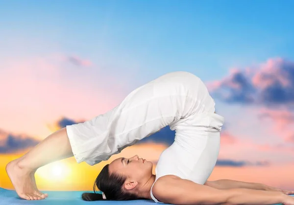 Mujer joven haciendo yoga —  Fotos de Stock