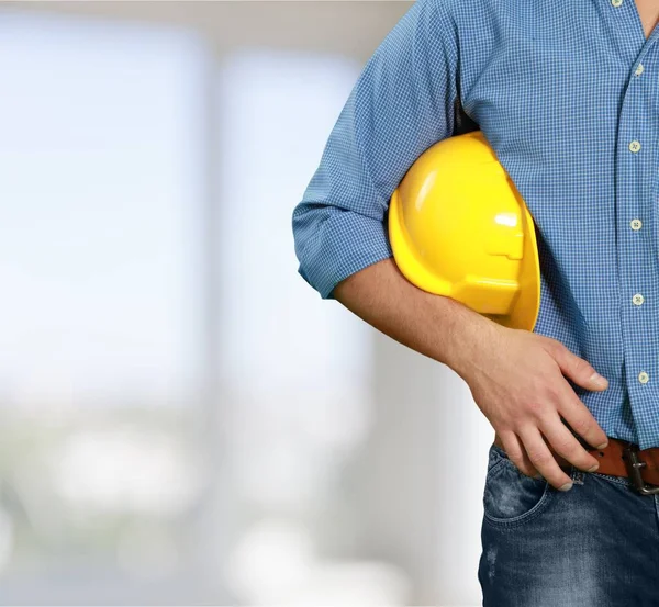 Empresario sosteniendo en la mano casco amarillo — Foto de Stock