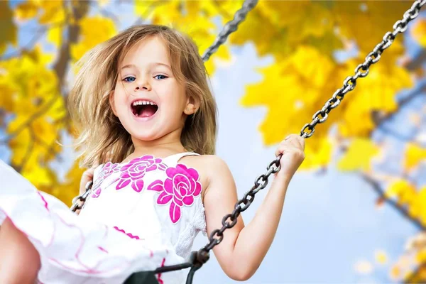 küçük kız salıncakta eğleniyor