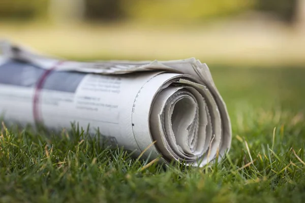 Газета на зеленой траве — стоковое фото