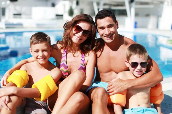 Família feliz brincando na piscina. — Fotografia de Stock