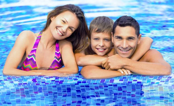 Familia feliz jugando en la piscina. — Foto de Stock