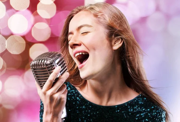Genç kadın mikrofonla şarkı söylüyor. — Stok fotoğraf