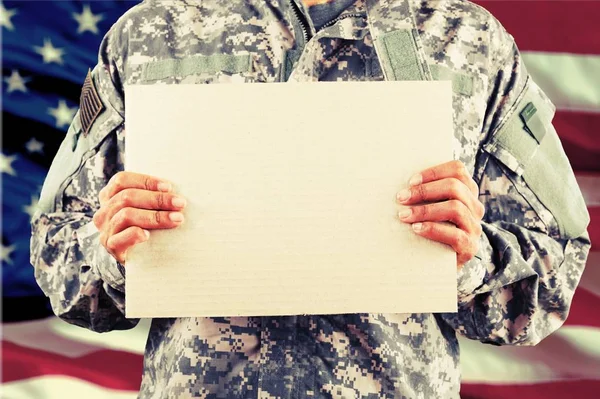 Homem militar segurando placa de sinal — Fotografia de Stock