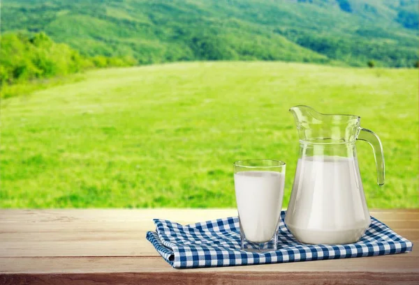 Glass of milk and jar — Stock Photo, Image