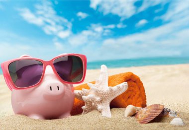 Sahilde güneş gözlüğü ile Piggy banka