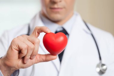 Kırmızı kalp tutan doktor
