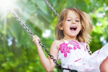 küçük kız salıncakta eğleniyor