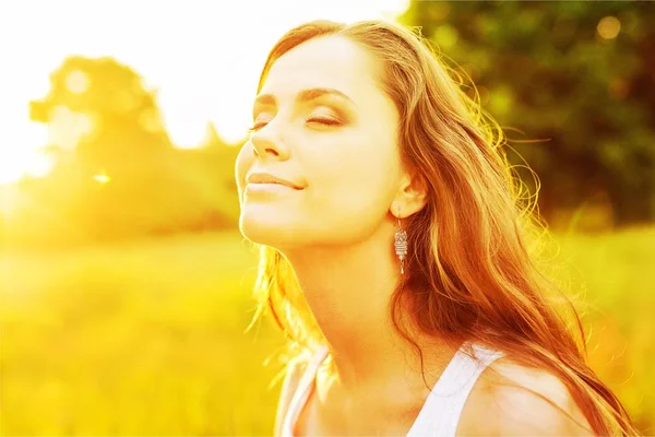 Vrouw onder zonsondergang licht — Stockfoto