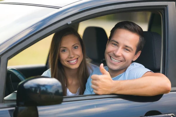 Jeune couple heureux en voiture — Photo