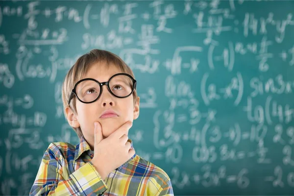 Boy in glasses near green blackboard — Stock Photo, Image