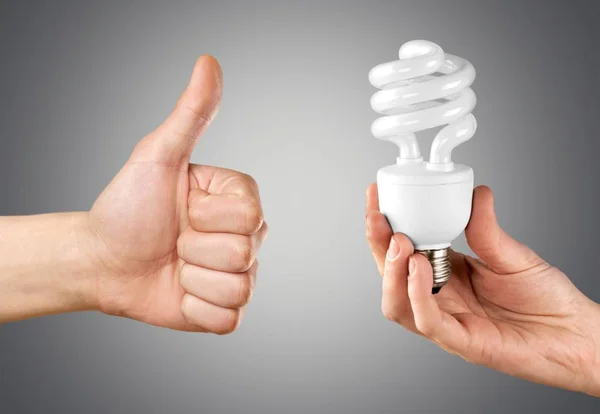 Mani che tengono lampada a lampadina — Foto Stock