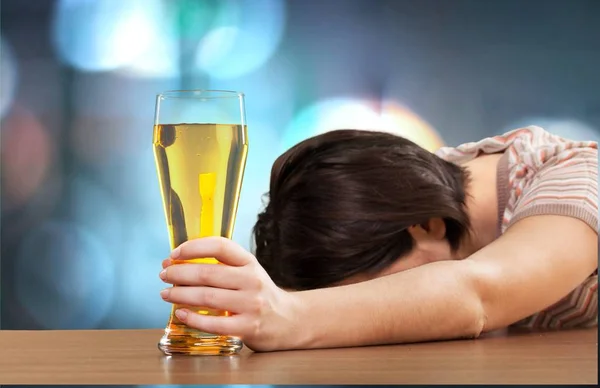 Пьяная женщина со стаканом пива — стоковое фото