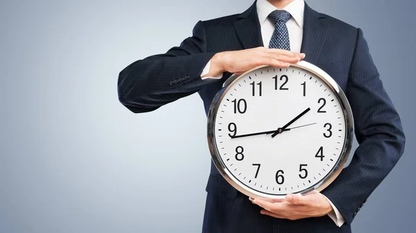 Geschäftsmann hält Uhr in Händen — Stockfoto