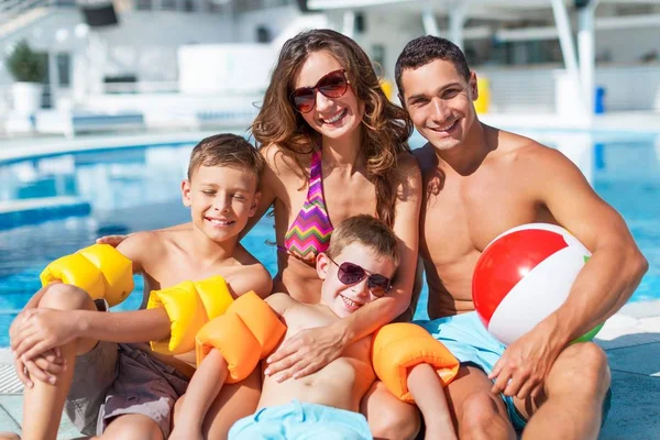 Familia feliz jugando en la piscina. — Foto de Stock