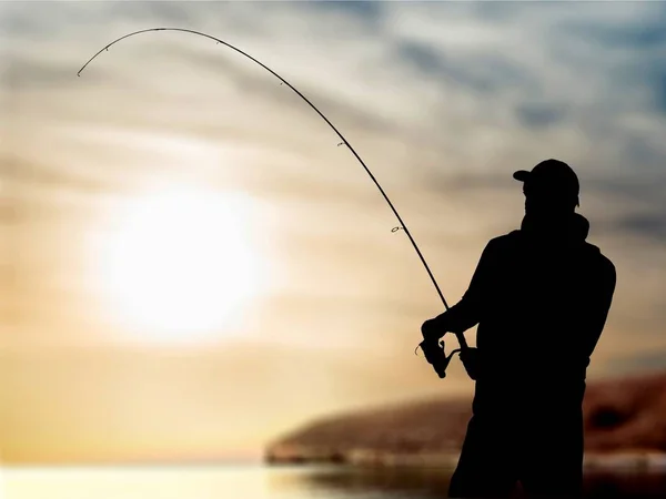 silhouette of fishing man