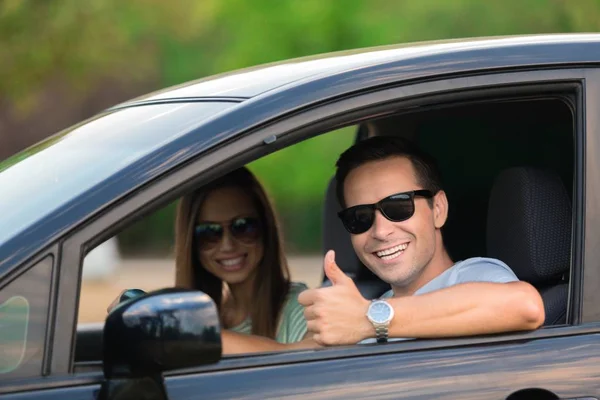 Jeune couple heureux en voiture — Photo